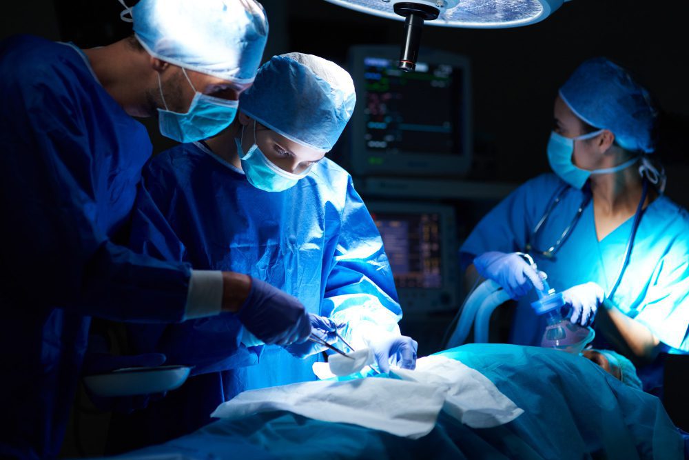 Orthopedic surgeons performing arthoscopy on patient to reduce ailments